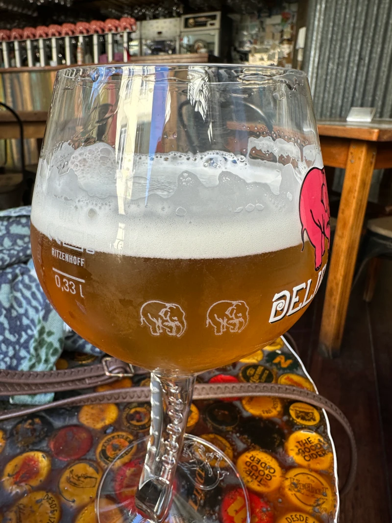 Delirium branded glass with a golden beer pour at Delirium Café Lisboa