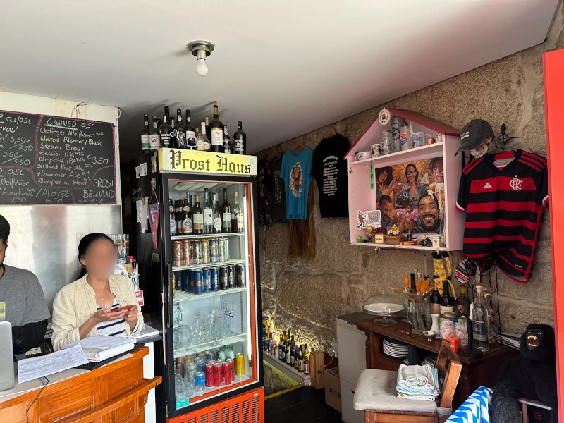 Interior bar area at Prost Haus Porto with German beer signage and family portrait on the wall