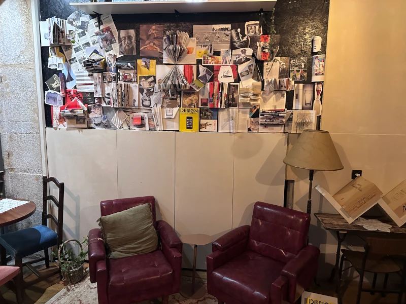 Street-level lounge at Sigilo Porto with armchairs and collage wall