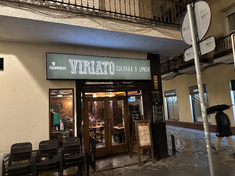 Exterior of Viriato bar and restaurant on a small Old Town square in Seville, with a church visible across the street